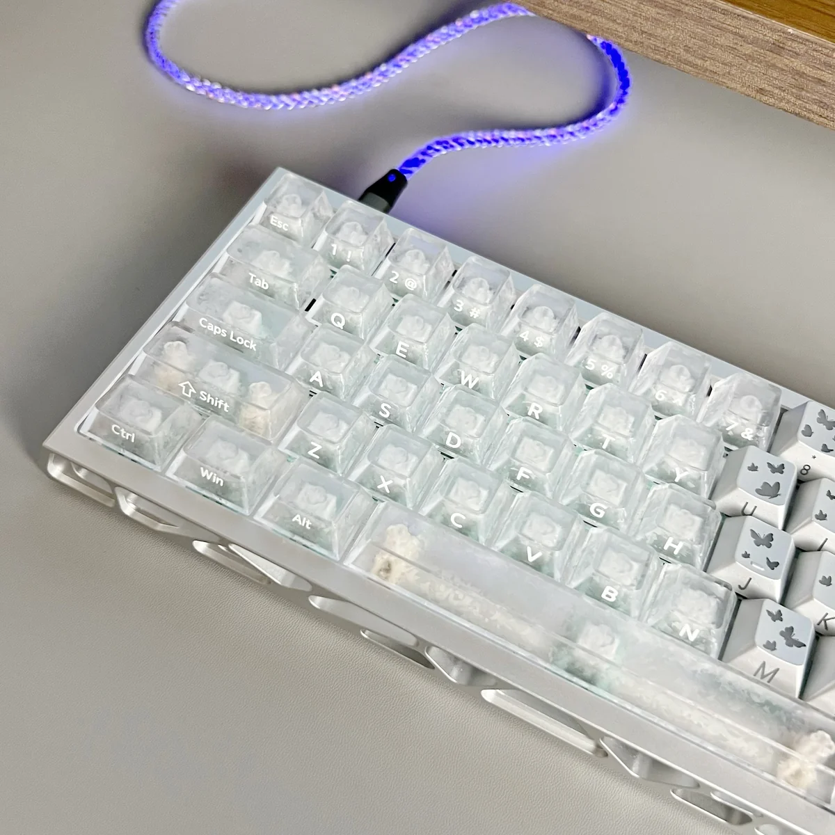 Forged carbon keycaps set shown from various angles, highlighting the unique textured surface and sleek side-lit legends for a premium gaming setup.