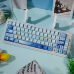 Whale Starlit Keycap Set, seen from an angle. Deep blue keys feature ethereal starlit whales and celestial patterns, a stunning oceanic and cosmic artistic.