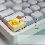 Vibrant yellow handcrafted ice cream keycap, a whimsical miniature scoop adding a delightful, realistic accent to any mechanical keyboard.
