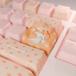 Hand-sculpted artisan cat keycap. Whimsical lounging feline on a cozy, colorful sofa, shown from angles. Charming miniature artistic design.