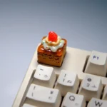 Handcrafted strawberry cream artisan keycap from various playful angles, highlighting its vibrant, delectable layered dessert fantasy and charming ice cream cake setup.