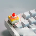 Multiple angles of a handcrafted delectable strawberry cream artisan keycap, showcasing its vibrant layers and whimsical dessert fantasy design.