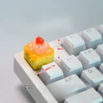 Handcrafted artisan keycap featuring a whimsical cheesecake design with creamy textures, part of a delectable dessert fantasy collection.