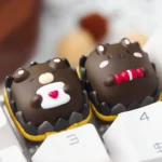 Whimsical chocolate animal artisan keycap, a handcrafted resin keycap with charming miniature chocolate creatures encased in clear resin.