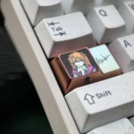 Iconic Asuka Titanium 1.75U Caps Key artisan keycap displayed from multiple angles, emphasizing its polished finish and anime character detail.