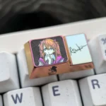 Iconic Asuka titanium artisan keycap gallery showing the detailed anime character art from multiple angles, highlighting its polished finish and premium setup.