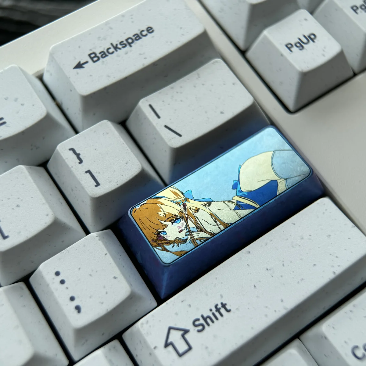 A collection of vibrant anodized Asuma Toki Titanium keycaps, meticulously crafted. Multiple angles reveal sleek metallic finishes and dynamic multi-tone colors,