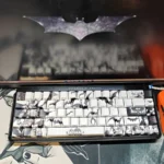 Iconic Batman PBT keycaps set featuring subtle, illuminated side-engraved legends, showcasing their shine-through effect against a dark, mysterious Gotham design.