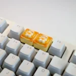 Side view of the handcrafted whimsical cat toast keycap, showcasing the adorable sleepy cat nestled on golden toast, a unique keyboard charm.
