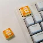 Another angle of the adorable handcrafted cat toast keycap, highlighting the sleepy feline nestled on golden toast. A whimsical artisan keyboard charm.