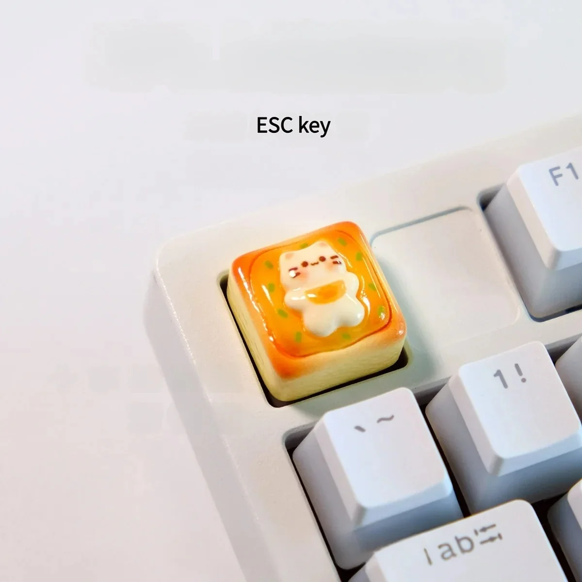 Handcrafted cat toast keycap showcasing an adorable sleepy cat miniature nestled on golden toast, a whimsical artisan keyboard charm.