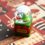 Gallery view of an artisan handcrafted Christmas crystal ball keycap, revealing intricate miniature Christmas wonderland scenes from multiple angles.