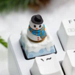Multiple angles of a handcrafted resin Christmas artisan ESC keycap, showcasing its blue winter wonderland theme with encased festive details.