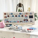 Artistic angled shot of Whimsical Christmas Whispers PBT keycaps set, revealing durable PBT construction and enchanting festive motifs with crisp legends.