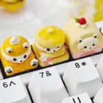 A close-up of a handcrafted Dessert Bear Keycap featuring an adorable resin bear charm nestled in a vibrant, miniature dessert scene. Playful and sweet.
