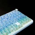 Frosted PC Keycaps Set, gradient translucent blue-white. Ocean-inspired, ethereal, light-diffusing summer aesthetic from varied angles.