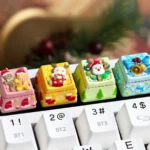 Close-up of a handcrafted Christmas keycap, a whimsical resin ESC art piece featuring vibrant miniature festive scenes.