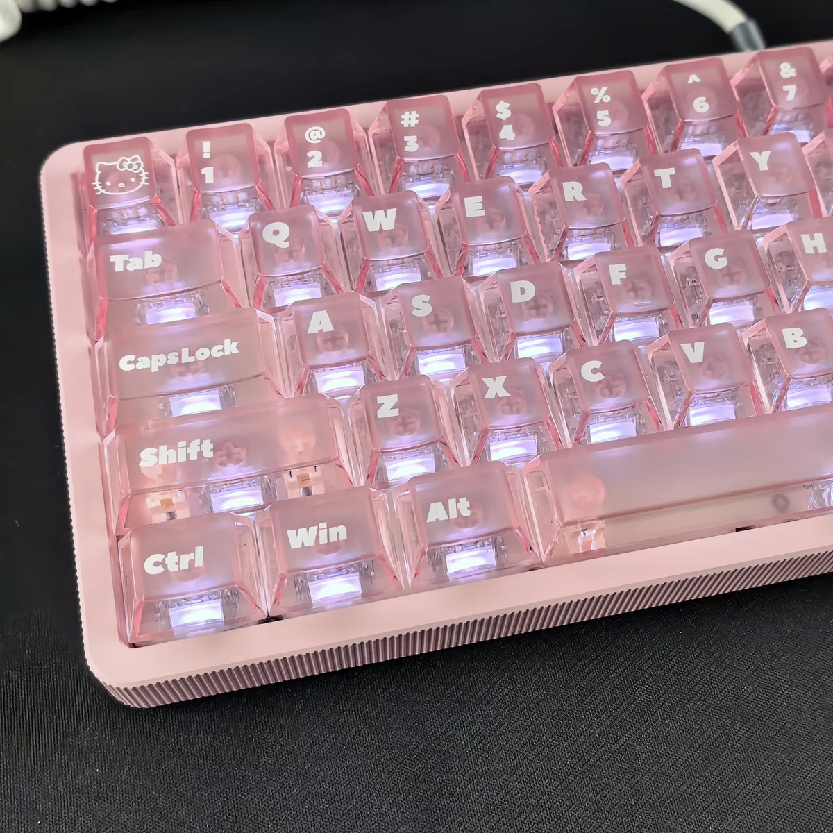 Detailed views of the playful Hello Kitty frosted pink backlit keycap set, showcasing its iconic face and soft, whimsical glow from various angles.