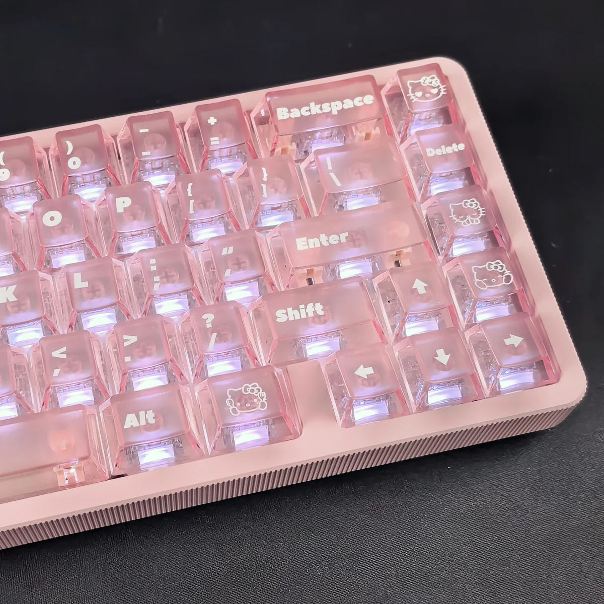 A playful Hello Kitty frosted pink backlit keycap set glowing softly from various angles, showcasing its whimsical design and translucent finish.