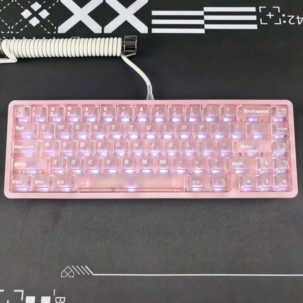 Close-up views of the whimsical Hello Kitty Frosted Pink Backlit Keycap set from various angles, highlighting its iconic design and soft, translucent glow.