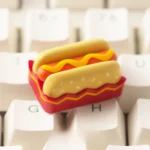Charming handcrafted hotdog artisan keycap for ESC, revealing its vibrant miniature food art and playful design from an appealing angle.