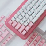 Elegant PBT Sakura dye-sub keycaps set, showcasing delicate pink cherry blossoms from multiple angles. Durable and premium quality.
