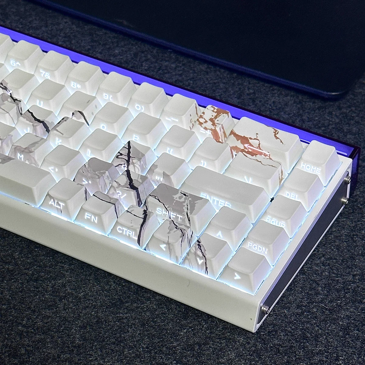 A collection of side-lit PBT marble keycaps set, showcasing their elegant side-engraved legends and natural texture from various angles, perfect for a premium setup.