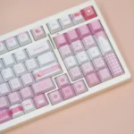 A collection of sweet Meiji Strawberry PBT keycaps set from various angles, showcasing the charming pink and white snack-inspired design.