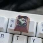 Different angles of the premium handcrafted Nezuko Titanium ESC keycap, highlighting its iconic Demon Slayer colors and intricate artisan details.