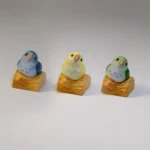 Vibrant, hand-sculpted Monk Parrot artisan keycap detail shot, revealing its whimsical 3D design and intricate textures for unique keyboard art.
