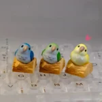 Vibrant hand-sculpted Monk Parrot artisan keycap for mechanical keyboards, showcasing whimsical 3D art and a charming touch of nature.