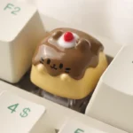 Close-up views of the handcrafted Pudding Cat Keycap, revealing its whimsical resin art, translucent layered design, and adorable 3D feline details.