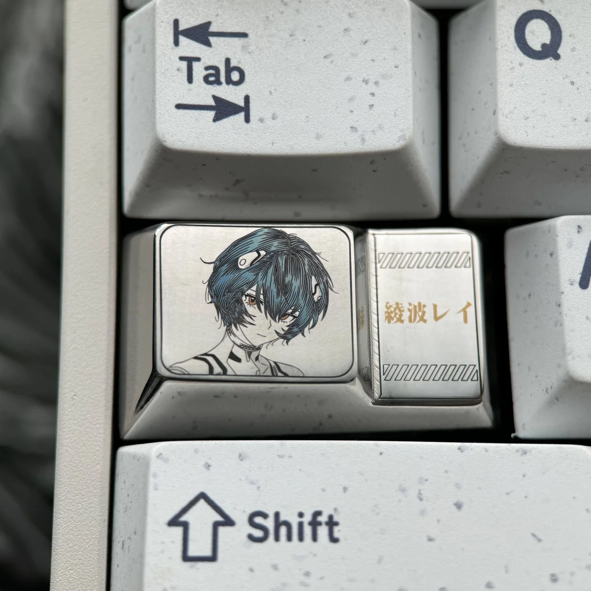 Artistic premium titanium Rei Ayanami 1.75U Caps Lock keycap, showcasing its mecha-inspired anime details and anodized metallic finish from various angles.