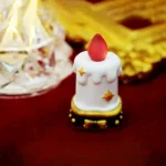 A detailed side view of the artisan resin candle keycap, highlighting its intricate layered resin and soft, ethereal glow, a unique handcrafted desktop.