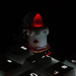 Close-up of a handcrafted resin candle keycap, showcasing its whimsical layered design and intricate details from a unique angle, an artisan desktop.