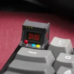 Handcrafted resin retro game console keycap for ESC, showcasing a backlit miniature arcade console with vibrant, illuminated details.