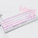 Artistic shot of Rose Coast Luminous Side-Engraved PBT Keycaps Set, revealing soft pink, orange, grey gradients and glowing legends from a unique angle.