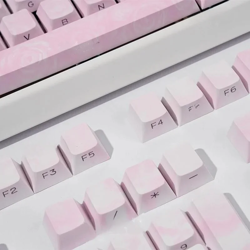 Rose Coast Luminous PBT keycaps set, side-engraved, shown from an artistic angle, revealing serene pink, orange, and grey gradient backlighting.