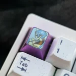 Close-up of premium titanium Sylphiette artisan keycap, showcasing vibrant anime art and polished finish from multiple angles.