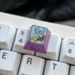Close-up views of the premium titanium Sylphiette artisan keycap for ESC, highlighting vibrant anime character art on polished metal from multiple perspective.