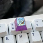 Premium titanium Sylphiette artisan keycap for ESC, viewed from multiple angles, highlighting vibrant anime character art on polished alloy.