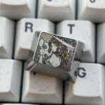 Close-up views of the Cartethyia precision-engraved titanium keycap, showcasing its aerospace-grade material and intricate metallic patterns from various angles.