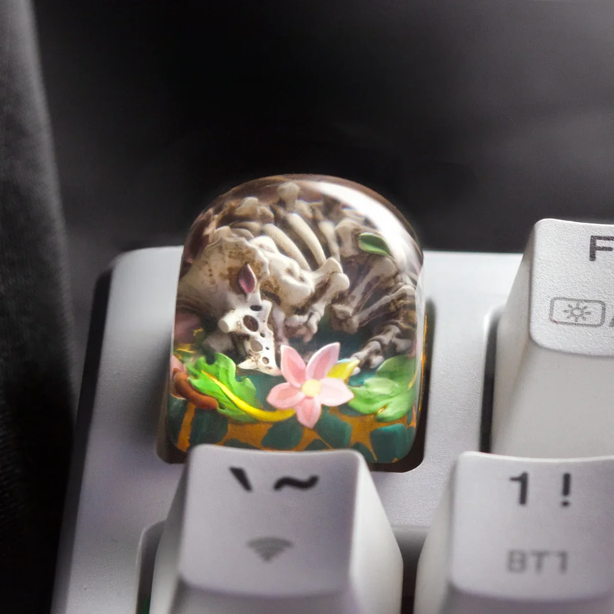 Handcrafted translucent resin Triceratops Skull Translucent Keycap glowing on a keyboard, showcasing intricate artisan detail of a miniature prehistoric dinosaur art design.