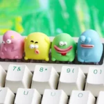 A collection of uniquely charming Ugly Cute keycaps, showcasing various handcrafted resin designs from different angles with vibrant, quirky details.