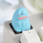 Close-up of a vibrant, handcrafted 'Ugly Cute' resin keycap from different angles, showcasing its unique texture and charming, quirky character design.