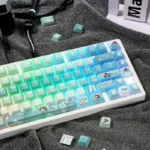 Close-up of Valorant Sage PBT dye-sublimated keycaps set from various angles, highlighting the serene green and white character art and tactical game motif.