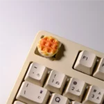 A delightful handcrafted waffle keycap for MX keyboards, showcasing its miniature, realistic design with warm textures from various angles.