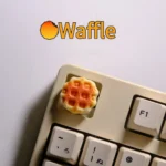 A delightful, handcrafted waffle keycap for MX switches, showcasing a miniature, realistic waffle sculpture with warm, inviting textures and colors.