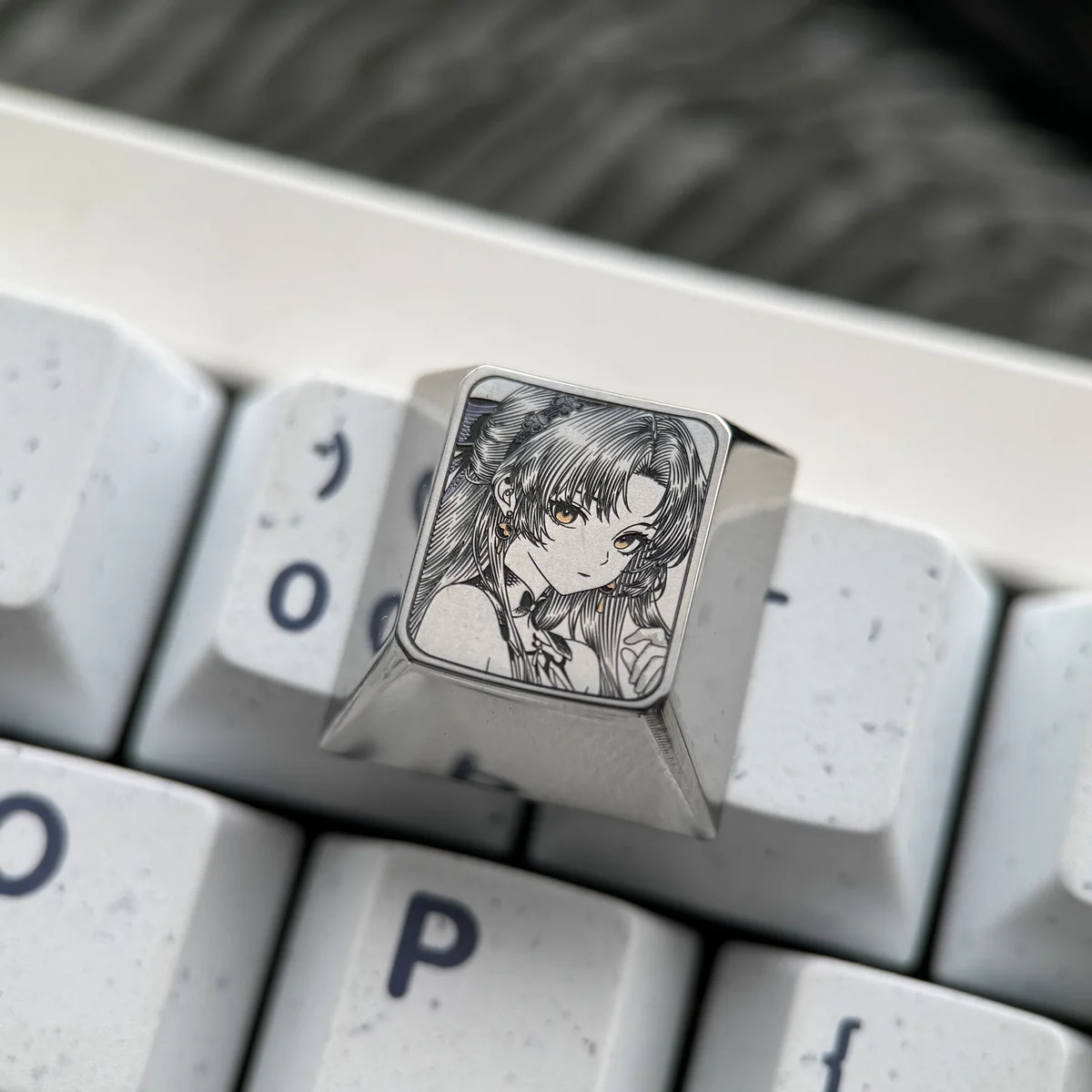Vibrant, precision-engraved Wuthering Waves Carlotta titanium keycap showcasing intricate character art on a reflective surface.