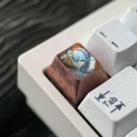 Close-up views of the premium Wuthering Waves Camellya titanium artisan keycap, showcasing its intricate metallic design and lustrous finish from multiple angles.